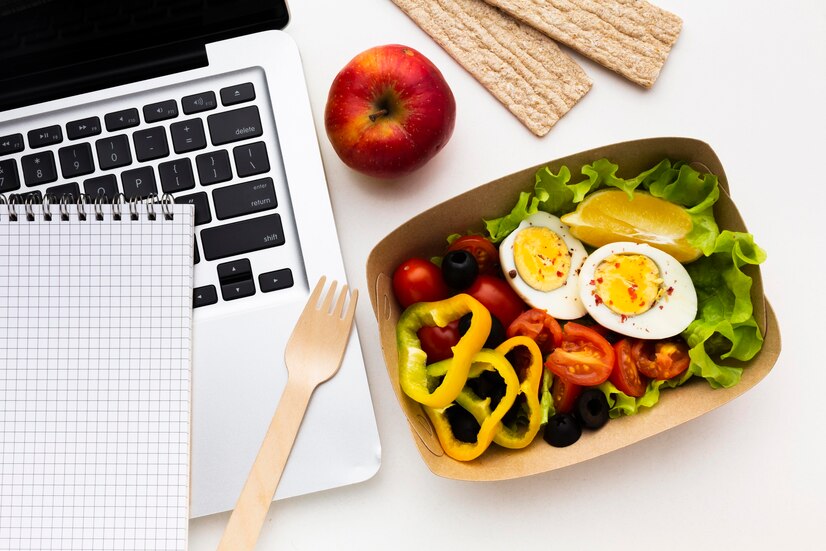 plato ensalada al lado de una laptop